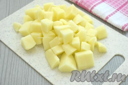 Пока бульон закипает, нужно очистить картошку, нарезать на средние кубики. В закипевший бульон выложить картошку, дать закипеть, уменьшить огонь и варить 15 минут (до мягкости картофеля).