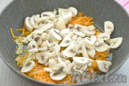 Шампиньоны нарезать на тонкие ломтики, выложить к обжаренным овощам, перемешать и готовить в течение 6-7 минут, иногда помешивая, а затем убрать с огня.