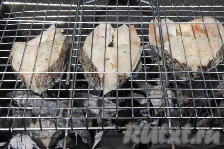 Поместить решётку с рыбой на мангал с раскалёнными углями.