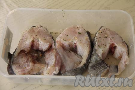 Выложить стейки в лоток, посолить, посыпать специями для рыбы, перемешать, покрывая рыбу солью и специями со всех сторон. Полить зубатку лимонным соком и оставить мариноваться в прохладном месте минимум на 1 час. Я в качестве специй взяла пряную соль с чесноком и зеленью.