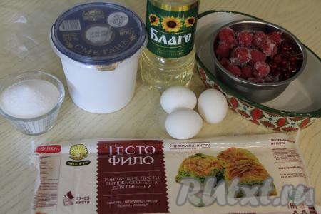 Подготовить продукты для приготовления пирога из теста фило с ягодами. Ягоды можно взять любые свежие или замороженные. Я взяла замороженные ягоды (клубнику, смородину, малину), их нужно разморозить, лишнюю воду слить. Если ягоды свежие, их нужно промыть водой, обсушить, если есть крупные косточки, их нужно удалить. Для этой выпечки можно взять 3 яйца размером С2 или 2 яйца размером С0. Тесто фило я купила в вакуумной упаковке, оно продаётся в незамороженном виде. Если у вас тесто фило заморожено, тогда его нужно полностью разморозить, не нарушая целостность упаковки. Сметану можно взять любой жирности, я купила жирностью 20%.