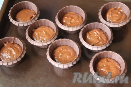 Разложить тесто по формочкам (я разложила по 8 формочкам), заполняя их на половину объёма. Я использовала бумажные формочки, но можно выпекать и в силиконовых или железных. Бумажные формочки перед выкладыванием теста маслом смазывать не нужно.