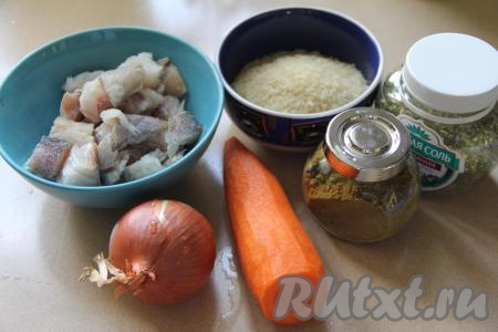 Подготовить продукты для приготовления минтая с рисом в мультиварке. Для этого блюда можно купить филе минтая, разморозить, нарезать на небольшие кусочки. А можно купить тушки минтая, разморозить рыбу, очистить от внутренностей и плавников, снять кожу, отделить филе от хребта и костей, после этого нарезать филе на небольшие кусочки. Всего нам потребуется 400 грамм филе минтая. Лук и морковь почистить. Рис хорошо промыть водой, а затем лишнюю воду слить.