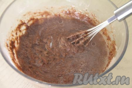 Аккуратно, чтобы не обжечься, тонкой струйкой, непрерывно перемешивая венчиком, влить в тесто частями крутой кипяток. Очень важно, вливая тонкой струйкой кипяток и тщательно перемешивая венчиком, контролировать густоту замешиваемого бисквитного шоколадного теста.