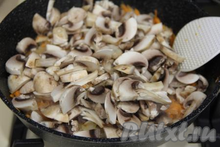 К обжаренным овощам добавить шампиньоны, нарезанные на пластинки, перемешать.