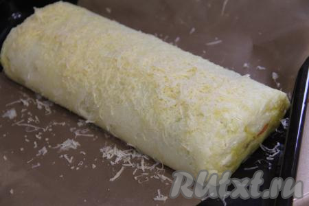 Поставить противень с картофельным рулетом с грибами в разогретую до 200 градусов духовку, запекать 20 минут. Затем достать противень, присыпать рулет сыром, натёртым на крупной тёрке. Вернуть рулет на 15 минут в духовку.