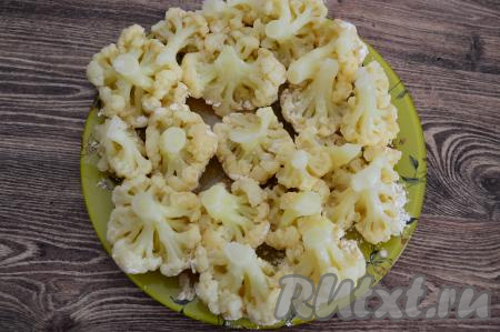 Соцветие цветной капусты, покрытое яйцом и мукой, выложить на плоскую тарелку. Постепенно таким образом подготовить все соцветия капусты, выкладывая их рядом на тарелку.