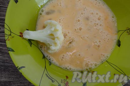 В яичный кляр, держа капусту за ножку, окунуть соцветие.