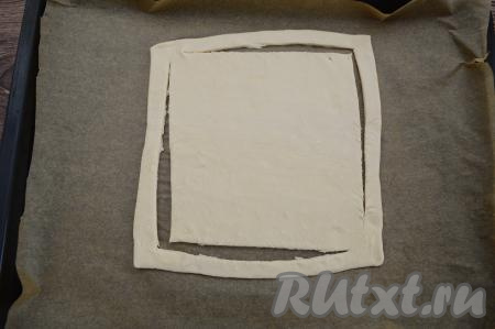 Переложить раскатанное тесто на противень, застеленный пергаментом. Отступив от краёв теста примерно 1 сантиметр, сделать острым ножом разрез по всему периметру квадрата,&nbsp; оставляя тесто не разрезанным в двух противоположных углах.&nbsp;&nbsp;