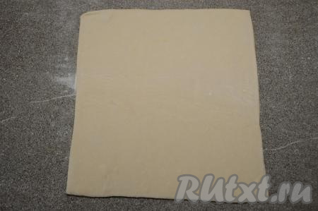 На столе, слегка присыпанном мукой, раскатать разморозившееся тесто в квадрат толщиной примерно 3 миллиметра. У меня получился квадрат со стороной 23 сантиметра.