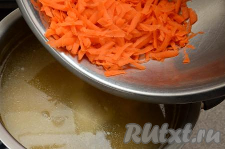 Достать куриные ножки из бульона, оставить остывать. А в кастрюлю с куриным бульоном и мягким горохом добавить очищенную морковку, натёртую на крупной тёрке.