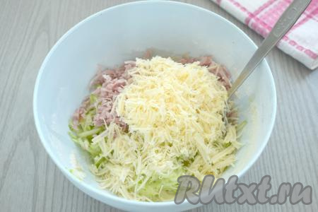 Следом выкладываем сыр, натёртый на крупной тёрке, тщательно перемешиваем.