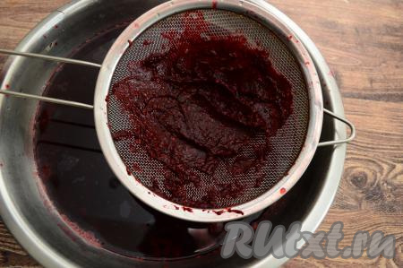 Готовый напиток снять с огня, дать ему остыть в течение нескольких минут, после этого процедить через сито в глубокую миску (или другую удобную посуду). В сите останутся ягоды. В миску с процеженным напитком протереть через сито варёную жимолость. В результате в миске будет напиток с мякотью, а в сите останется практически сухой жмых (жмых можно выбросить).