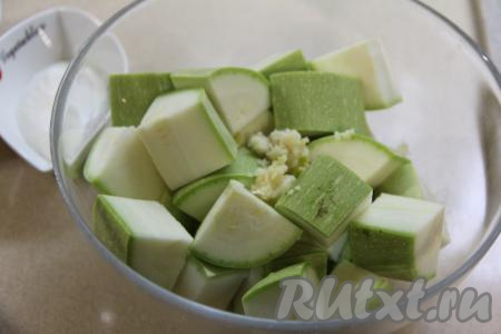 Переложить кусочки кабачков в миску, добавить пропущенный через пресс чеснок.&nbsp;