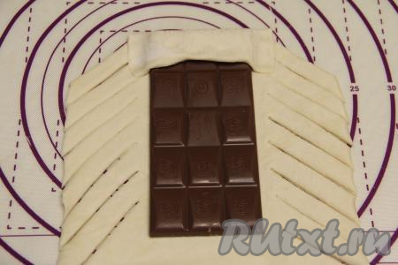 Закрыть край шоколадки более коротким краем теста, хорошо прижимая края теста.