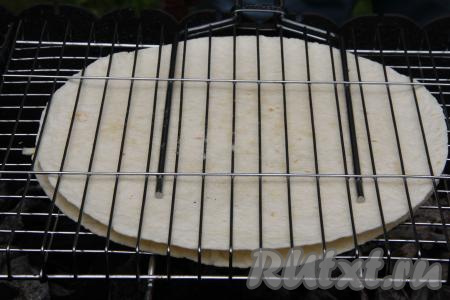 Поместить решётку с тортильей с сыром на мангал с горячими углями. Угли должны быть раскалёнными, но прямого огня быть не должно.