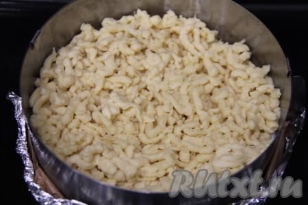 Достать из морозилки вторую часть теста и, натерев на крупной тёрке, равномерно распределить его поверх начинки, покрывая весь творог.&nbsp;