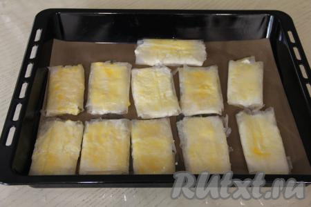 Яичный желток, который мы откладывали, в небольшой мисочке взбить вилкой до однородности, а затем смазать им поверхность пирожков.