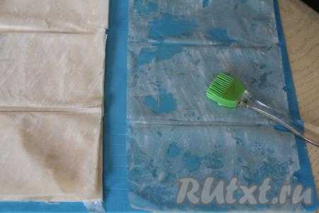 Вначале один лист теста фило выложить на рабочую поверхность, с помощью силиконовой кисточки обильно смазать его растительным маслом. Вместо растительного масла можно использовать растопленное сливочное масло. Тесто фило очень любит масло, поэтому и смазывать его нужно очень хорошо.