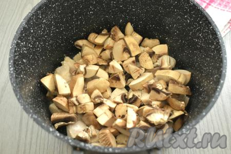 Пока обжаривается мясо, моем шампиньоны, обсушиваем, нарезаем на средние кубики. К обжаренному мясу выкладываем шампиньоны, перемешиваем. Обжариваем курицу с грибами 6-7 минут, иногда помешивая.