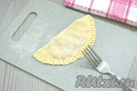 На одну сторону лепёшки, отступая по 1-1,5 сантиметру от краёв, выкладываем 2 чайных ложки фарша, распределяя его тонким слоем. Накрываем свободной стороной лепёшки, края плотно прижимаем и фиксируем вилкой. Постепенно лепим все чебуреки с фаршем из теста, замешанного на пиве.