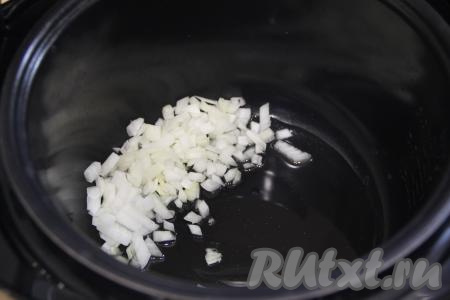 В чашу мультиварки влить растительное масло, выставить на 15 минут режим "Жарка". Выложить в чашу мультиварку мелко нарезанную луковицу, обжарить до прозрачности (на обжаривание потребуется 4-5 минут), периодически помешивая.