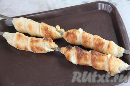 Жарить хачапури с сыром, часто переворачивая шампуры, минут 7 (слоёное тесто должно стать золотистого цвета, сыр внутри должен расплавиться).