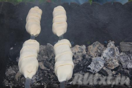 Подготовленные шампуры с сыром, завёрнутым в слоёное тесто, выложить на мангал с разогретыми углями. Сильный жар для жарки&nbsp;хачапури на мангале&nbsp;нам не нужен, прямого огня быть не должно.