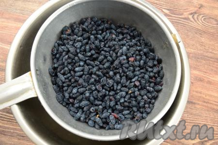 Жимолость перебрать, удаляя сор и листочки. Затем выложить ягоды в сито, тщательно промыть холодной водой. Оставить жимолость в сите на несколько минут, чтобы стекла лишняя вода.