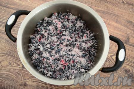По прошествии 40-50 минут ягоды начнут выделять сок. Переложить жимолость, смешанную с сахаром, в кастрюлю с толстым дном (или любую другую посуду, пригодную для приготовления варенья).