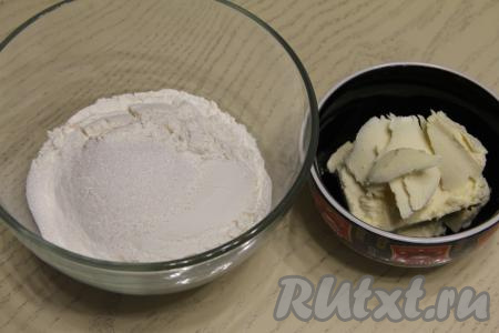 В миску всыпать просеянную муку, соль и сахар. Сливочное масло достать из холодильника, нарезать на кусочки.