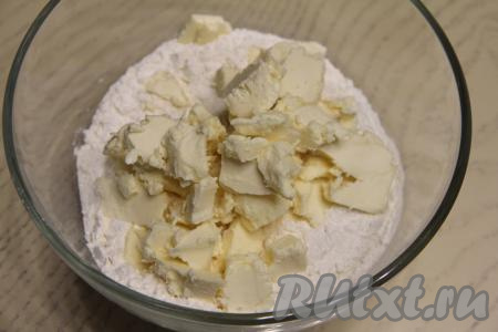 В миску с мукой, солью и сахаром выложить кусочки холодного сливочного масла.