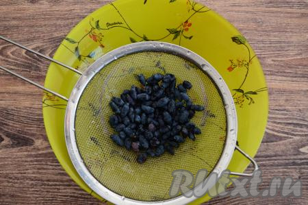 Жимолость перебрать, удаляя листочки и сор, затем выложить в сито, хорошо промыть под проточной водой. Оставить в сите на несколько минут, чтобы с ягод стекла лишняя вода. 