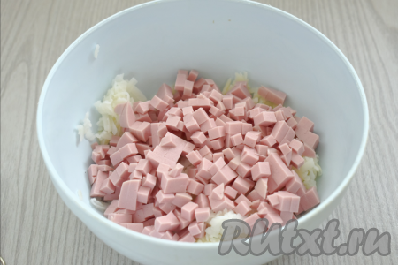 С колбасы убираем оболочку. Нарезаем варёную колбасу на мелкие кубики, перекладываем в миску с картофелем.