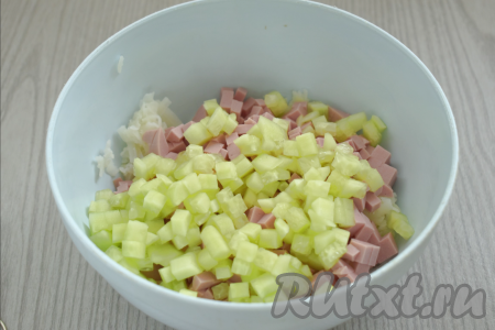 Огурцы моем, очищаем от кожуры, нарезаем на кубики такого же размера, как нарезана колбаса, тоже выкладываем в миску с колбасой и картошкой.