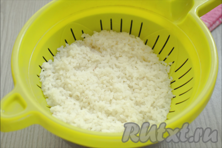 Рис промываем, перекладываем в кастрюлю, заливаем достаточно большим количество воды, ставим на огонь. После закипания перемешиваем рис, варим 10 минут (до полуготовности) на небольшом огне. Затем откидываем рис на дуршлаг, оставляем остывать.