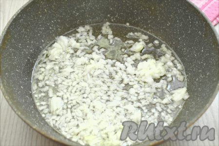 Пока отваривается рис, сразу приступаем к обжариванию овощей. Для этого очищаем морковку и лук. В сковороде прогреваем растительное масло, выкладываем мелко нарезанную луковицу. Обжариваем лук до прозрачности (в течение 3-4 минут), иногда перемешивая, на среднем огне.