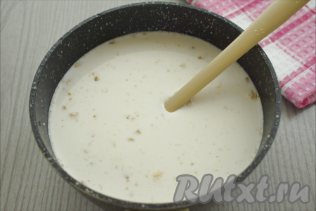 К овсяным хлопьям и сахару вливаем воду и сливки, перемешиваем, ставим на огонь.