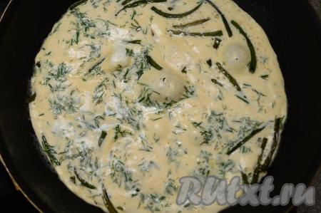 Омлет с чесночными стрелками готовить в течение 3-4 минут. Яичная масса должна полностью схватиться и не иметь влажных участков.