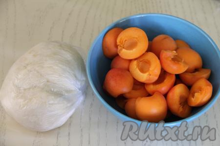 Тесто поместить в пакет и оставить на кухонном столе на 20 минут. Абрикосы вымыть, удалить косточки.&nbsp;