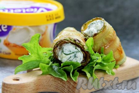 Аппетитные, очень вкусные, ароматные рулетики, приготовленные из кабачков с начинкой из творожного сыра и чеснока, переложить на тарелку и в качестве закуски подать к столу.