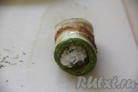 Завернуть полоску кабачка в рулетик, начиная с края с начинкой. Постепенно сформировать все рулетики (я сформировала 8 штук).