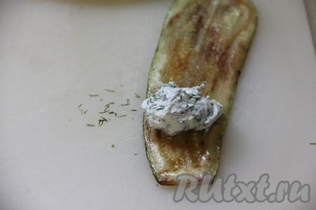 Немного отступив от более узкого края полоски из кабачка, выложить 1 чайную ложку начинки.&nbsp;