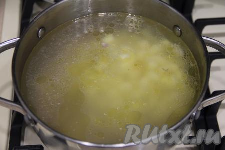 В закипевший бульон с кусочками курицы добавить картошку, нарезанную на небольшие кубики, дать закипеть, после этого варить на небольшом огне минут 20 (до готовности картофеля).