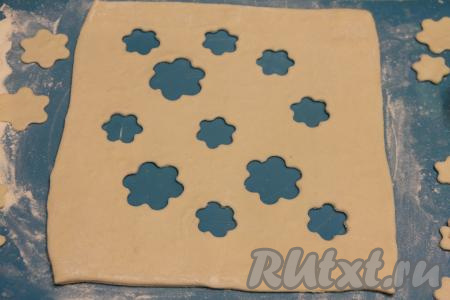 Вторую часть слоёного теста раскатать в пласт такого же размера, как был раскатан первый пласт. Сделать с помощью вырубки для печенья цветочки (можно просто сделать надрезы ножом).