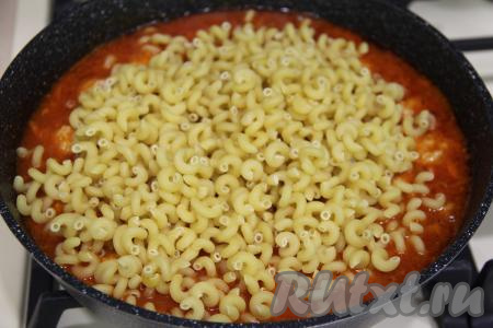 В сковороду с фрикадельками и закипевшим томатным соусом всыпать сухие макароны.