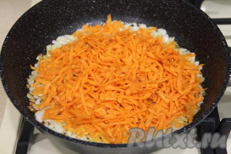К луку, обжаренному до приятного золотистого цвета, выложить натёртую на крупной тёрке морковку, сразу перемешать овощи.&nbsp;