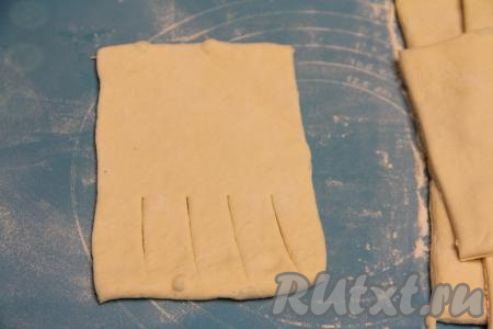 Зрительно каждую заготовку теста разделить на две половины. На одной половине заготовки, отступив от краёв теста по 1-1,5 сантиметра, сделать 4 разреза.