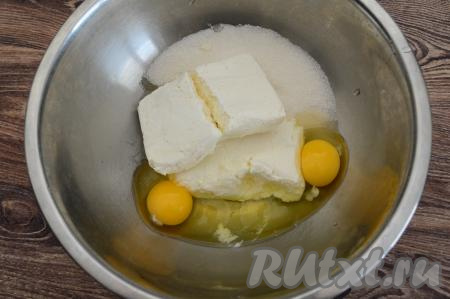 В миску всыпать сахар, выложить творог, вбить сырые яйца.