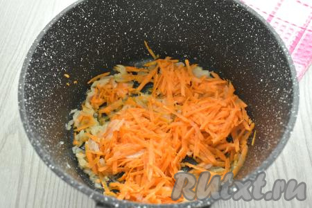 В кастрюле с толстым дном (или в глубокой сковороде) разогреваем растительное масло, выкладываем в него достаточно мелко нарезанную луковицу и обжариваем её минуты 3 (до прозрачности), иногда помешивая, на среднем огне. К обжаренному луку добавляем морковку, натёртую на крупной тёрке, сразу же перемешиваем овощи, обжариваем их минут 5 (морковка должна стать достаточно мягкой), иногда помешивая.